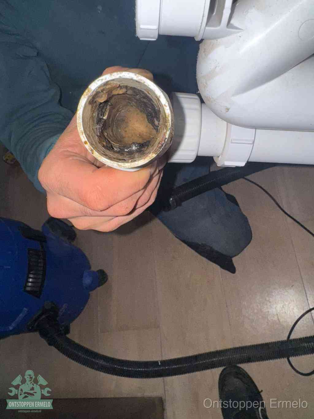 Een losgekoppeld PVC-afvoerbuisstuk dat van binnen volledig is dichtgeslibd met vet en vuil, de meest voorkomende oorzaak van verstoppingen in Ermelo