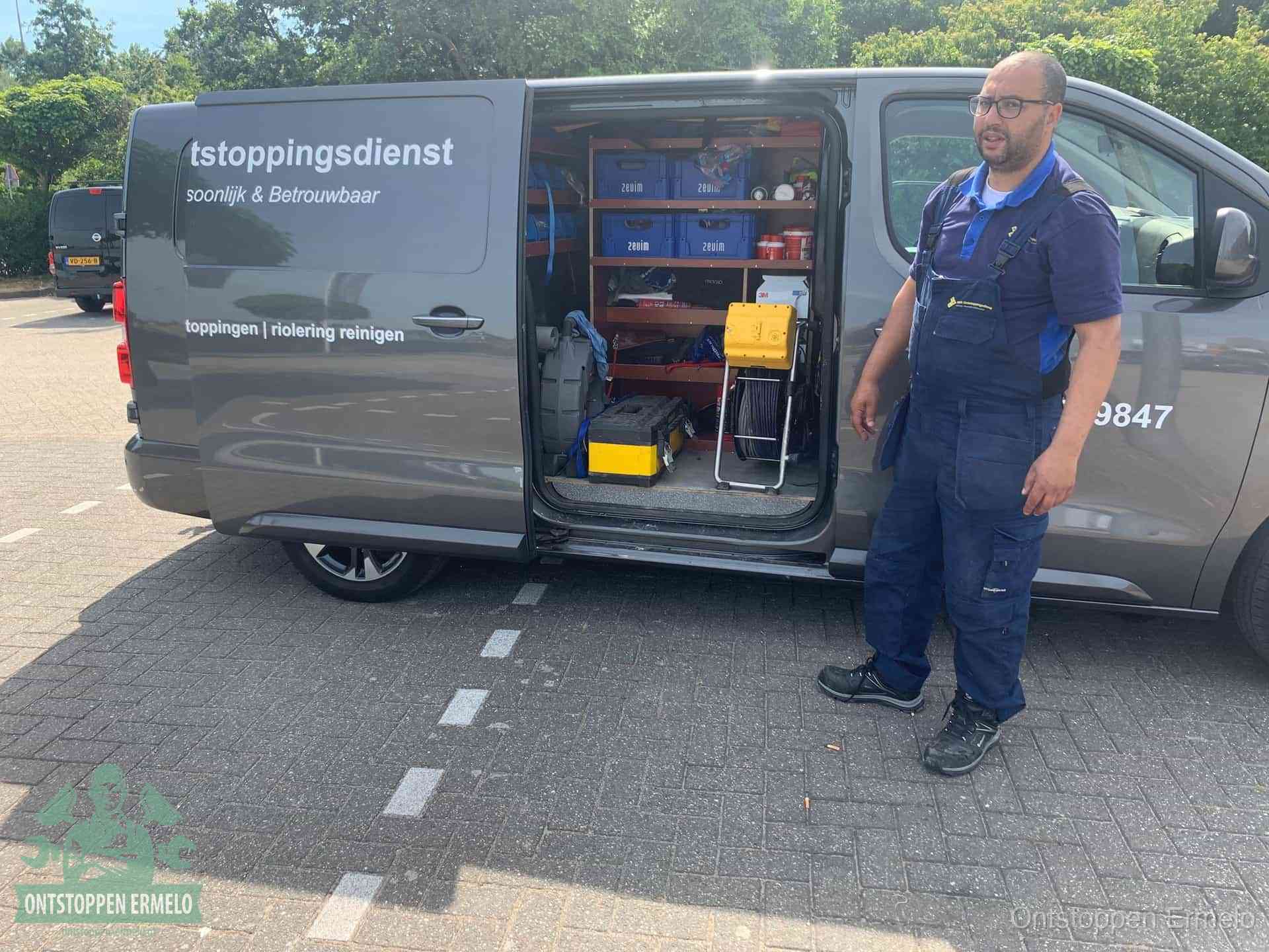 Een monteur staat klaar bij zijn bedrijfsbus met gereedschap, de vaste werkwijze van de ontstoppingsdienst in Ermelo